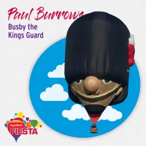 A hot air balloon shaped like a King's Guard with a busby hat at the ExxonMobil Fiesta against a blue sky with clouds.