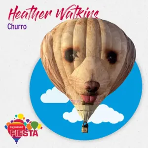 Hot air balloon shaped like a dog's face with a basket below, set against a blue circle with clouds. Fiesta logo included.