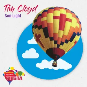 Colorful hot air balloon floats against a blue sky with clouds.