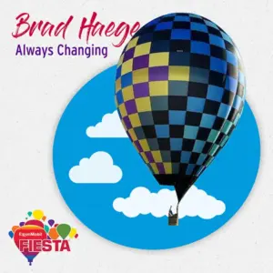 Colorful checkered hot air balloon floating against a sky backdrop with clouds, promoting ExxonMobil Fiesta event. Text reads: