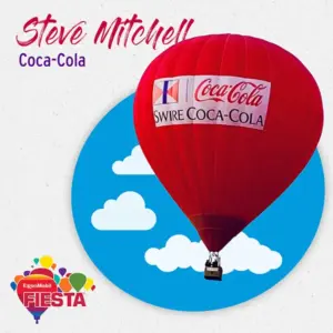 Red hot air balloon with Coca-Cola branding against blue sky and clouds.