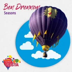 A colorful hot air balloon with a smiling sun design floats against a blue sky with clouds, promoting the ExxonMobil Fiesta event.