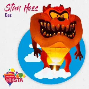 A cartoon character-shaped hot air balloon with fiery colors at the ExxonMobil Fiesta, against a blue sky with clouds.