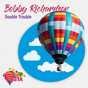 A colorful hot air balloon floats against a blue sky with clouds.