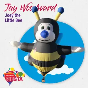 A cartoon bee-shaped hot air balloon against a blue sky backdrop, featured at an event named Fiesta, sponsored by ExxonMobil.