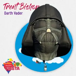 Balloon shaped like Darth Vader's helmet against blue sky and clouds background. Text reads