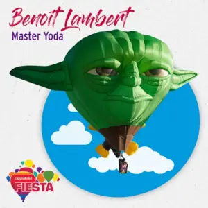 A hot air balloon shaped like Master Yoda floats against a blue sky backdrop with clouds; part of the ExxonMobil Fiesta event.