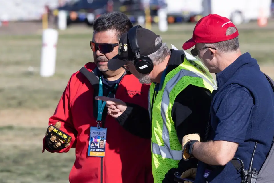 balloon-fiesta-live-crewperson-on-field07 Three Balloon Fiesta staff in discussion on Balloon Fiesta field
