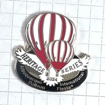 A pin featuring red and white hot air balloons, labeled "Heritage Series 2024" on grid background.