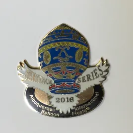 2016-Honoree-Jacqueline-Hockey A colorful pin depicting a hot air balloon design with intricate patterns, labeled "Albuquerque Balloon Fiesta 2018" in elegant and bold font.
