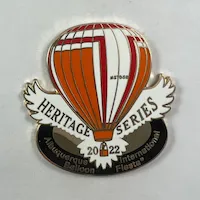 2022-Honoree-Paul-Smith A pin featuring a hot air balloon design labeled "Heritage Series 2022" with "Albuquerque Balloon International Fiesta" text. Bold orange and white colors.
